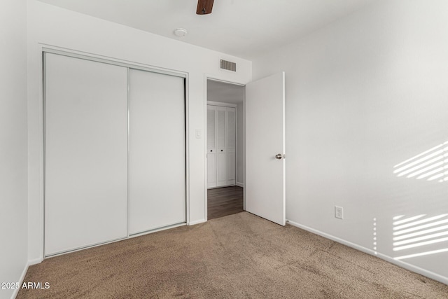 unfurnished bedroom with light colored carpet, ceiling fan, and a closet