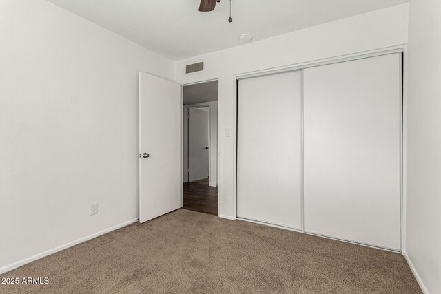 unfurnished bedroom featuring carpet flooring, ceiling fan, and a closet