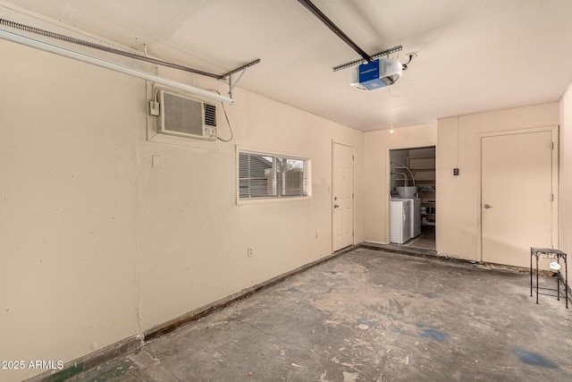 garage featuring a garage door opener, independent washer and dryer, and a wall mounted AC