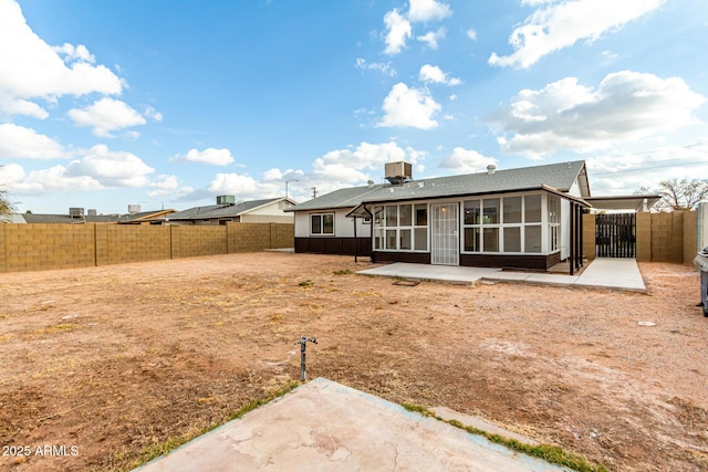 rear view of house with a patio area and a sunroom