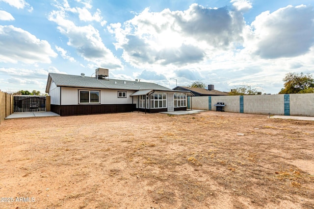 rear view of house with a patio, a sunroom, and central AC