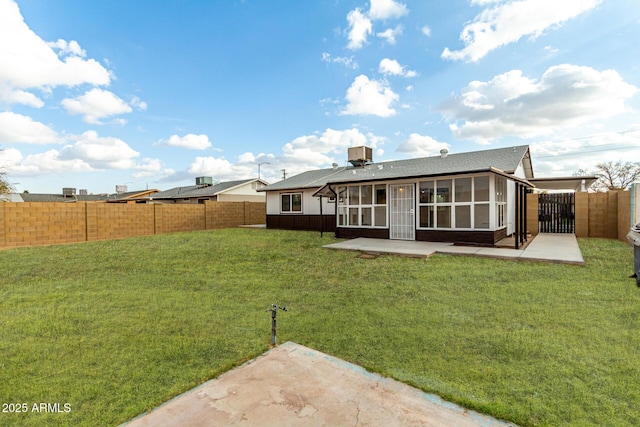 rear view of property with a sunroom, a patio area, and a lawn