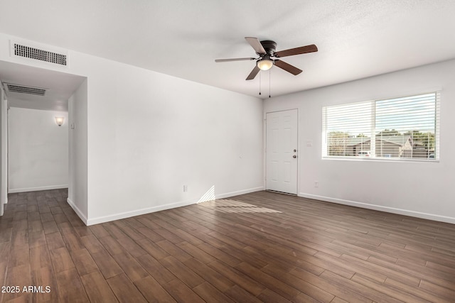 empty room with ceiling fan and dark hardwood / wood-style flooring