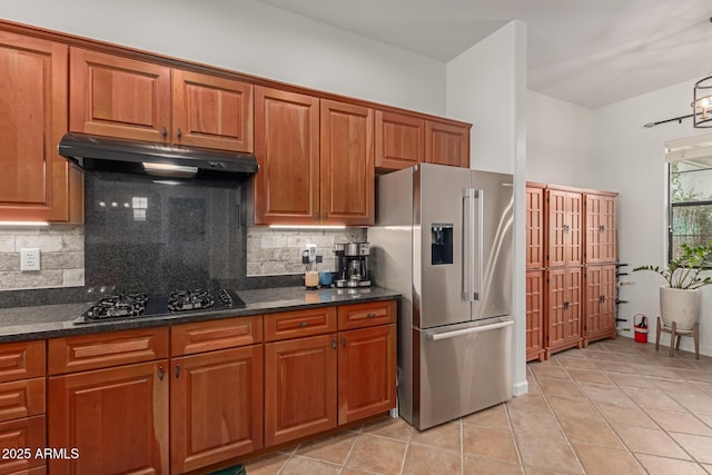 kitchen featuring backsplash, stainless steel fridge, black gas stovetop, and light tile patterned floors