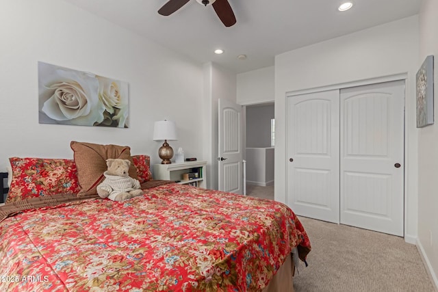 bedroom featuring a closet, ceiling fan, and light colored carpet