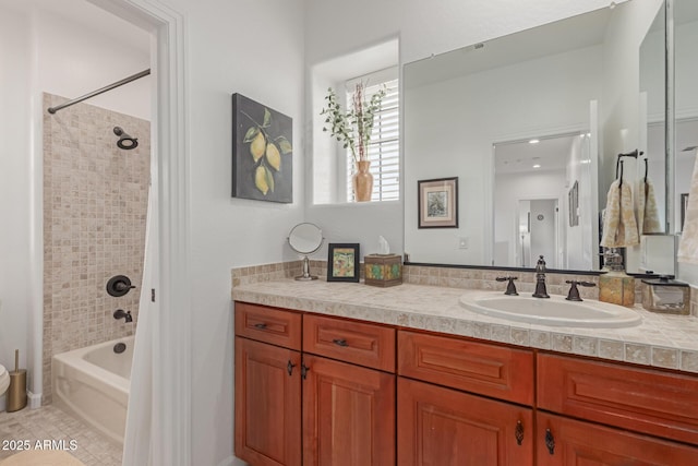 bathroom with tile patterned flooring, vanity, and tiled shower / bath