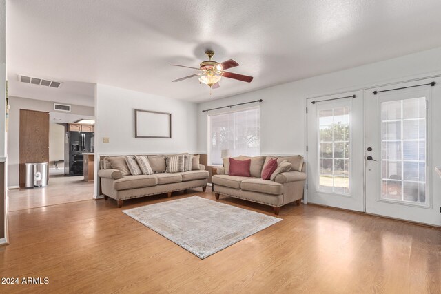 living room with french doors, wood-type flooring, and ceiling fan