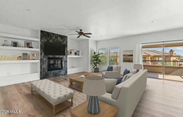 living area with baseboards, a tile fireplace, a ceiling fan, and light wood-style floors