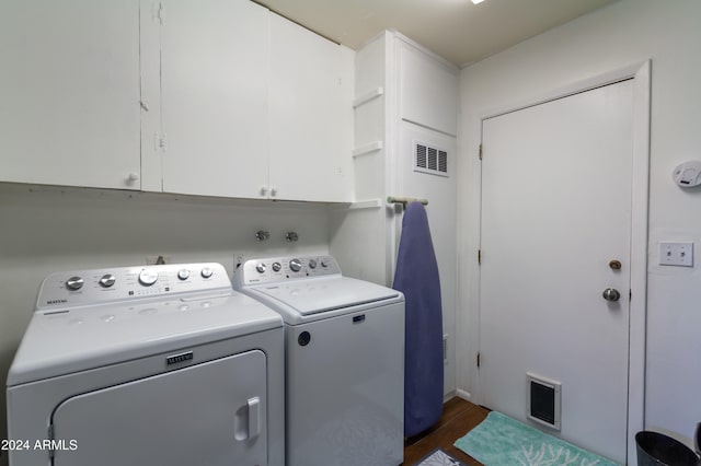 laundry area featuring cabinets, dark wood-type flooring, and washing machine and clothes dryer