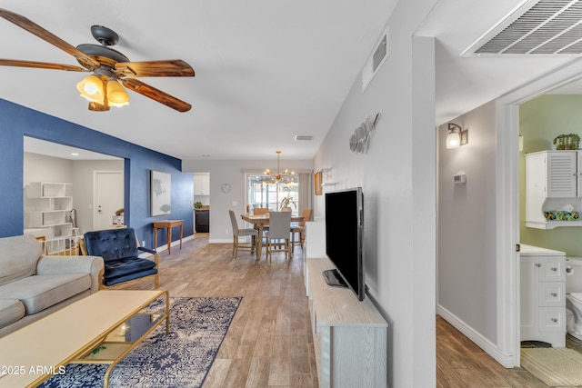 living area with baseboards, visible vents, and light wood finished floors