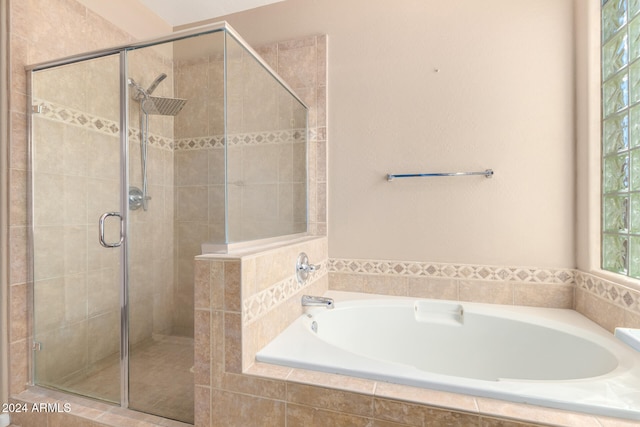 bathroom featuring shower with separate bathtub