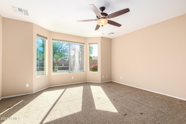 carpeted spare room with ceiling fan