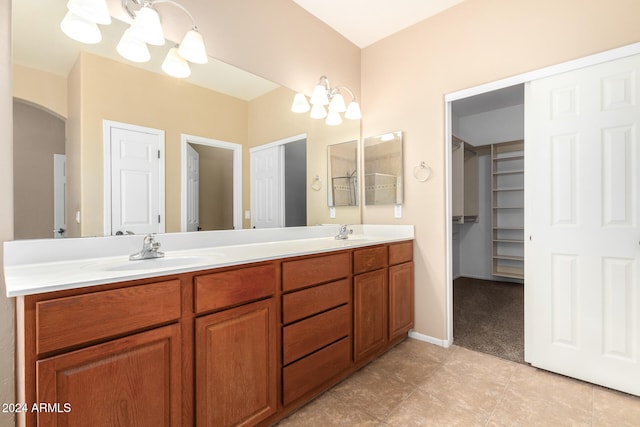 bathroom with tile patterned flooring, vanity, and a chandelier