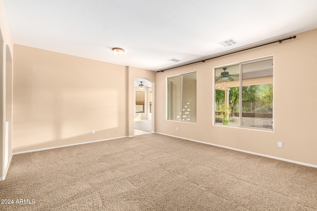 carpeted spare room featuring ceiling fan