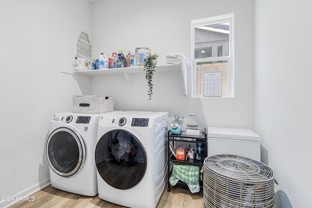 washroom with light hardwood / wood-style flooring and washing machine and dryer