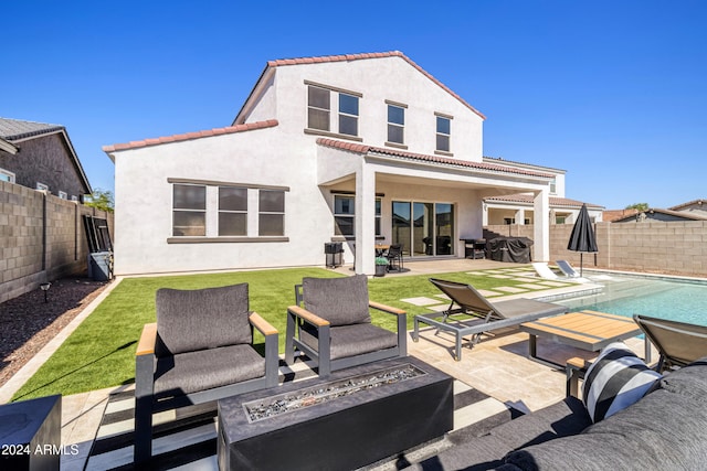 rear view of house with an outdoor hangout area, a patio, and a fenced in pool