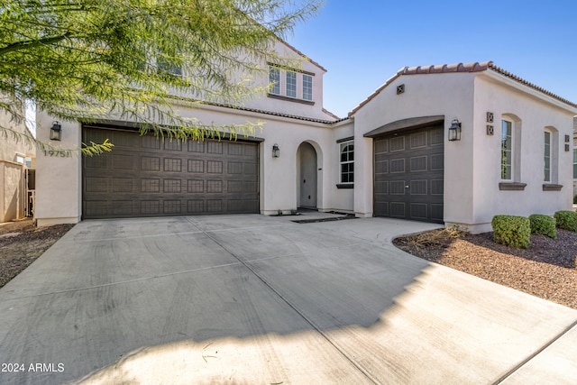 mediterranean / spanish-style home with a garage