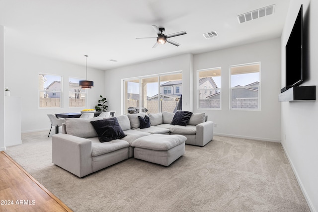 living room featuring light wood-type flooring, a healthy amount of sunlight, and ceiling fan