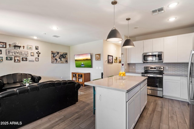 2753 E Fossil Ridge Rd, Phoenix, AZ 85050 - kitchen with appliances with stainless steel finishes, open floor plan, wood finished floors, and recessed lighting