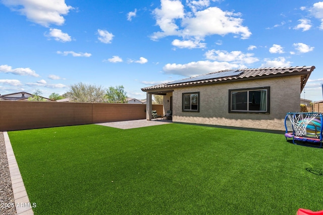2753 E Fossil Ridge Rd, Phoenix, AZ 85050 - rear view of house featuring a trampoline, stucco siding, a patio, and a fenced backyard