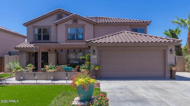 mediterranean / spanish-style house with a tile roof, an attached garage, driveway, and stucco siding