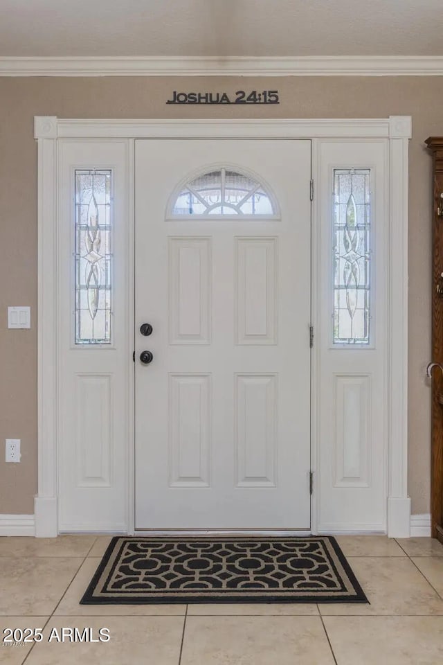 foyer entrance with baseboards, light tile patterned flooring, and ornamental molding