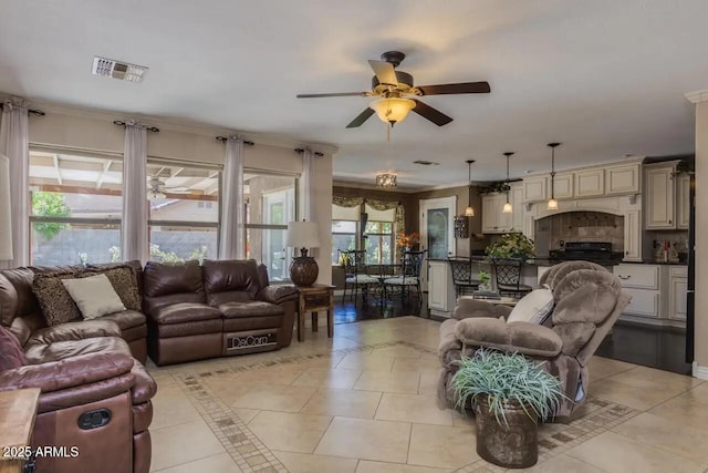 living area with light tile patterned flooring, visible vents, and a ceiling fan