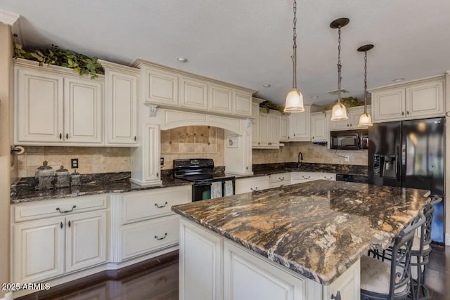 kitchen with backsplash, a center island, pendant lighting, a kitchen breakfast bar, and black appliances