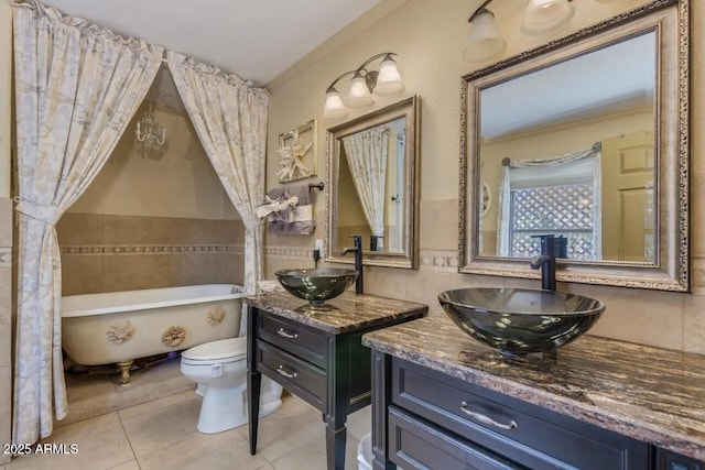 full bathroom featuring tile patterned flooring, toilet, a tub, and a sink