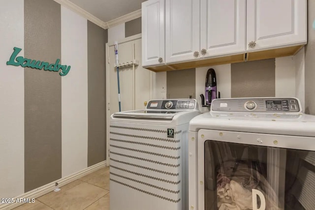 laundry area featuring cabinet space, crown molding, light tile patterned floors, baseboards, and washing machine and clothes dryer