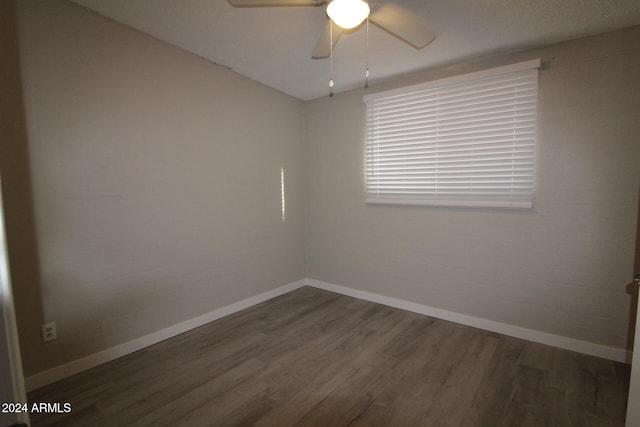 empty room with ceiling fan and dark hardwood / wood-style flooring