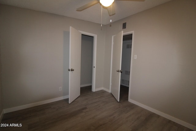 unfurnished bedroom with dark wood-type flooring and ceiling fan