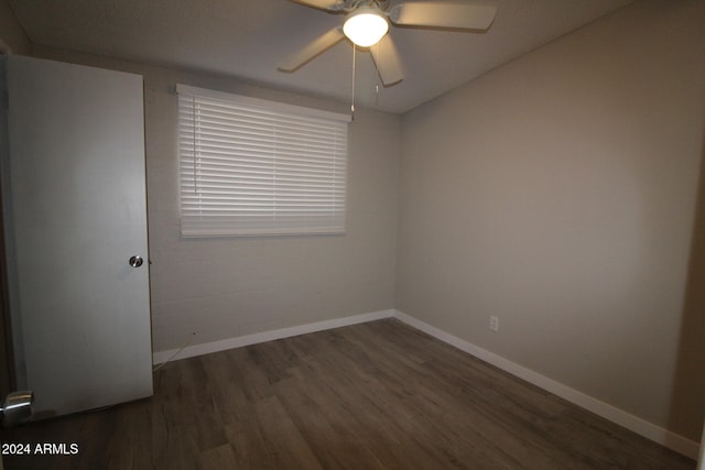 unfurnished room featuring dark wood-type flooring and ceiling fan