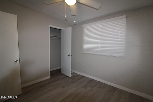 unfurnished bedroom featuring a closet, dark hardwood / wood-style floors, and ceiling fan