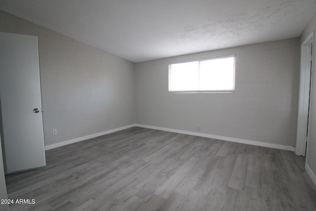 unfurnished room featuring a textured ceiling and wood-type flooring