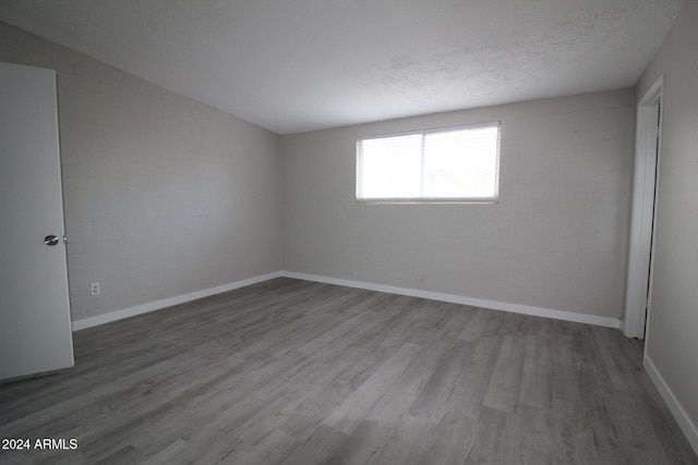 spare room with a textured ceiling and hardwood / wood-style floors