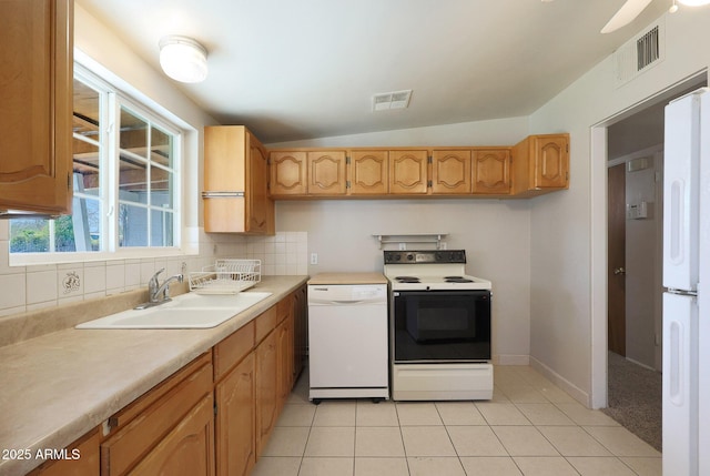 kitchen featuring sink, white appliances, light tile patterned floors, tasteful backsplash, and vaulted ceiling