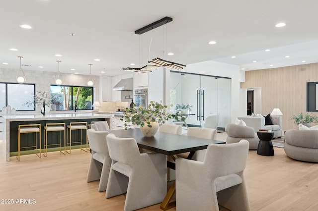 dining room with light wood-style flooring and recessed lighting
