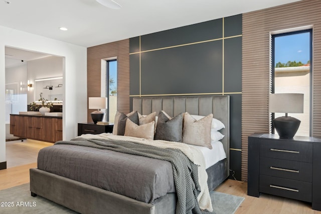 bedroom with recessed lighting, light wood-style flooring, and ensuite bathroom