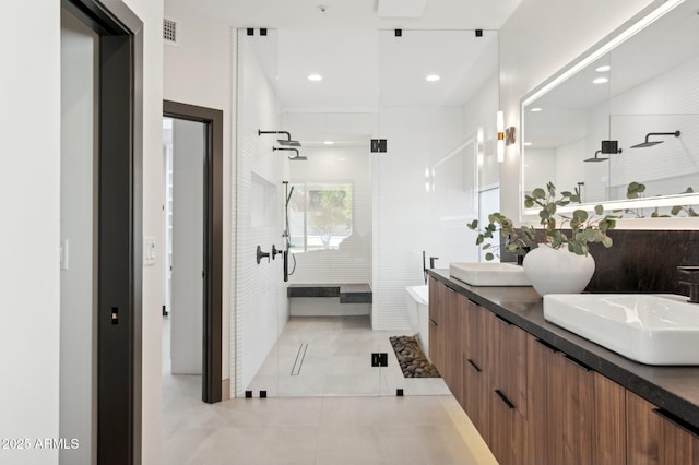 bathroom featuring tile patterned flooring, visible vents, double vanity, tiled shower, and a sink