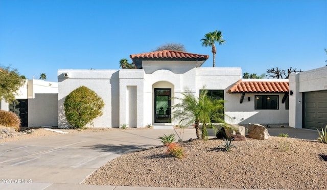 mediterranean / spanish house with stucco siding and a tile roof