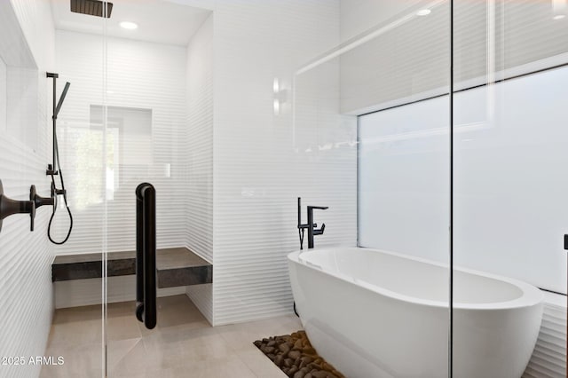 full bath featuring visible vents, a freestanding tub, tile patterned floors, an enclosed shower, and tile walls