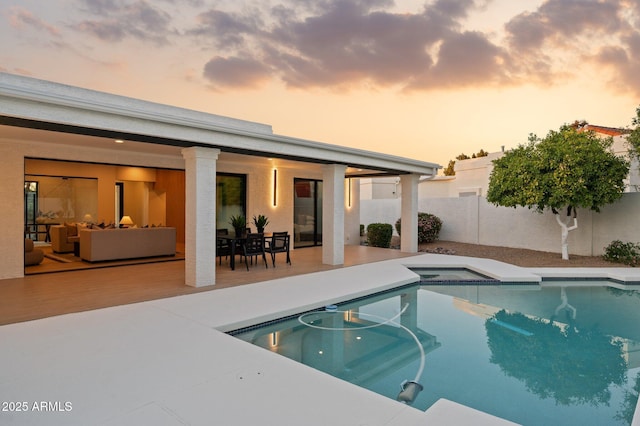 pool at dusk with an outdoor living space, a fenced in pool, and fence