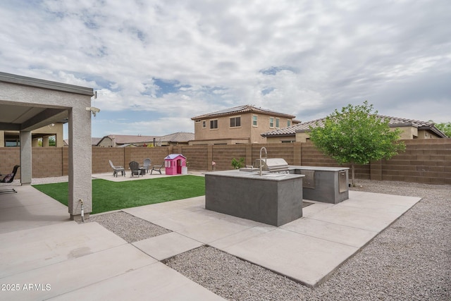 8513 N 172nd Ln, Waddell, AZ 85355 - view of patio featuring a fenced backyard and an outdoor kitchen