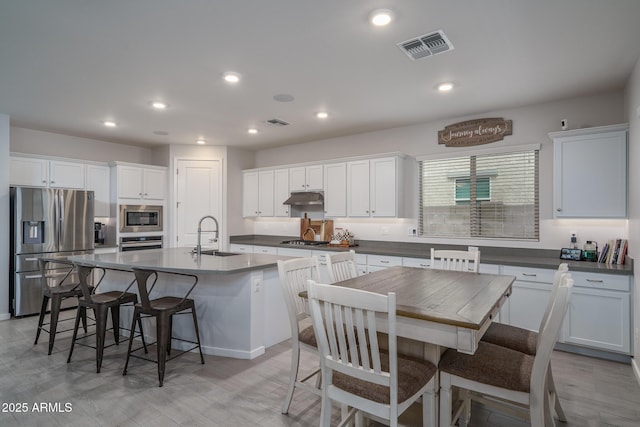 8513 N 172nd Ln, Waddell, AZ 85355 - kitchen with visible vents, a center island with sink, a breakfast bar area, appliances with stainless steel finishes, and a sink