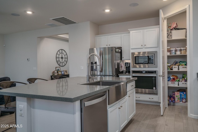 8513 N 172nd Ln, Waddell, AZ 85355 - kitchen featuring stainless steel appliances, visible vents, light wood-type flooring, and white cabinetry
