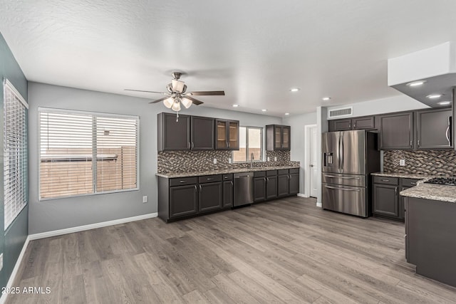 10440 E Osage Ave, Mesa, AZ 85212 - kitchen with stainless steel appliances, decorative backsplash, a ceiling fan, light wood-style floors, and recessed lighting