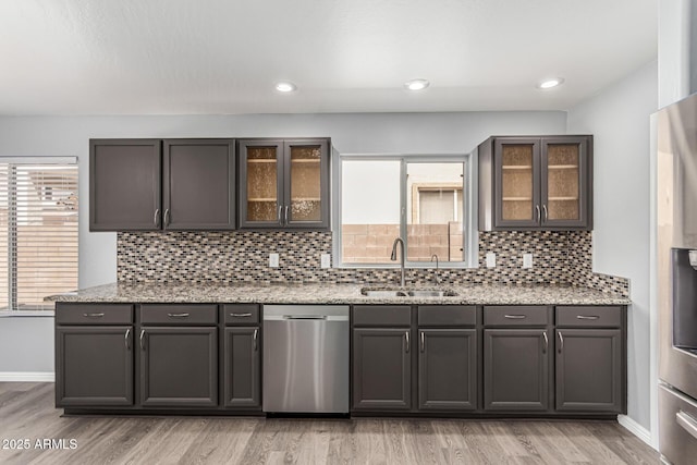 10440 E Osage Ave, Mesa, AZ 85212 - kitchen with stainless steel dishwasher, a sink, light wood-type flooring, tasteful backsplash, and light stone countertops