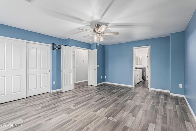 10440 E Osage Ave, Mesa, AZ 85212 - unfurnished bedroom featuring baseboards, wood finished floors, a closet, a ceiling fan, and ensuite bath
