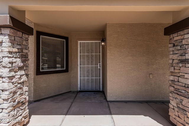 10440 E Osage Ave, Mesa, AZ 85212 - property entrance featuring stucco siding, a patio area, and stone siding